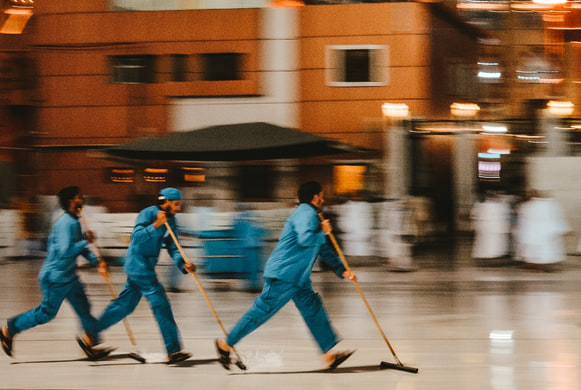 janitorial workers sweeping floors quickly at the airport to prevent disruption